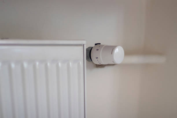 istock Adjusting the radiator temperature using a thermostat in an apartment with central heating 2149601050