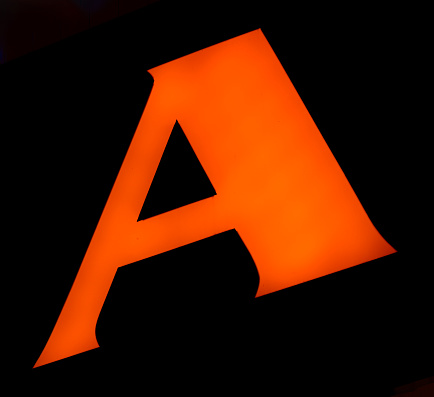 vibrant orange 'A' shines with confidence against the darkness, its form perfect and imposing