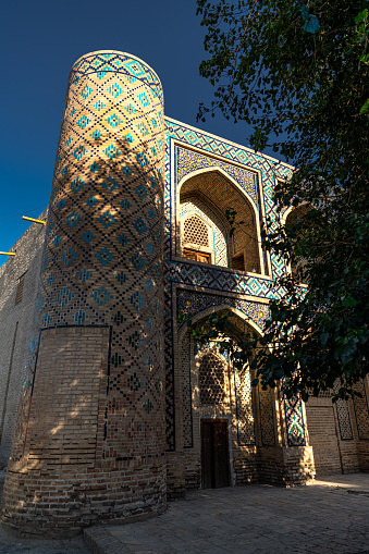 JUNE 27, 2023, BUKHARA, UZBEKISTAN: View over the Poi Kalon Mosque and Minaret at the sunset, in Bukhara, Uzbekistan. Vertical image with copy space for text