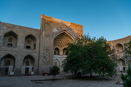 JUNE 27, 2023, BUKHARA, UZBEKISTAN: Walls of the ancient mosque of Bukhara in Uzbekistan. Ancient religion complex on a sunny day, blue sky with copy space for text