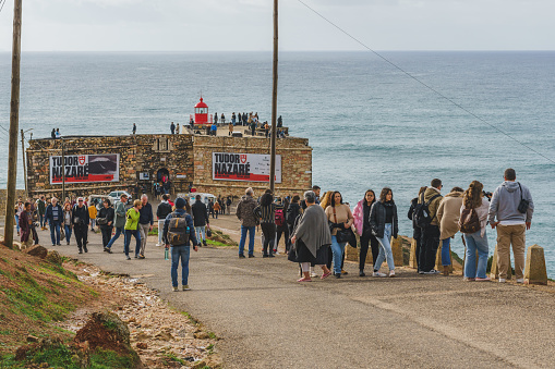 Nazare, Portugal, January 4, 2024. Crowds gather at Nazare's lighthouse to watch the legendary waves and surfers.