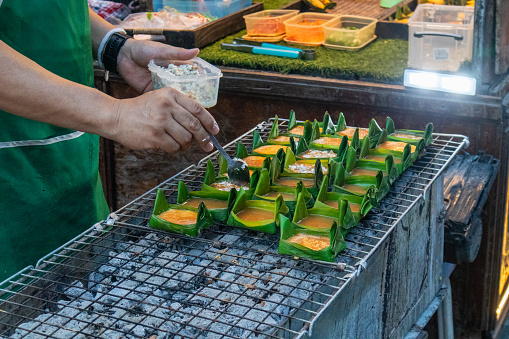 Making steamed eggs on a pan or stove and wrapped in banana leaves, a local food of northern Thailand.