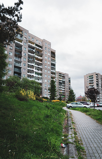 A grassy area with a neat row of apartment buildings in the background. The green grass is well-maintained, and the buildings are uniform in design. The overall scene suggests urban living with communal outdoor space.