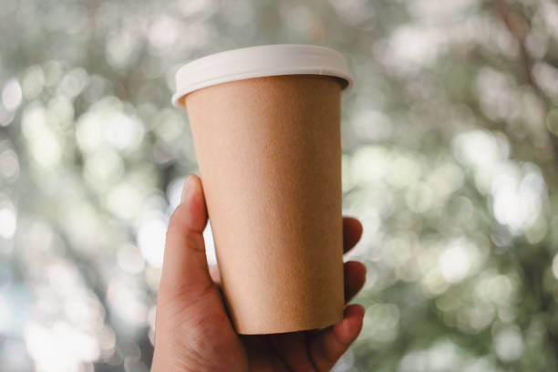 istock Hand holding one brown coffee paper cup with a lid. 2149608562