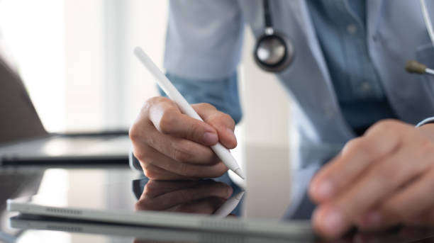 istock Doctor using stylus pen writing prescription for patient on digital tablet computer, electronic health record, medical insurance, health technology, close up 2149609426