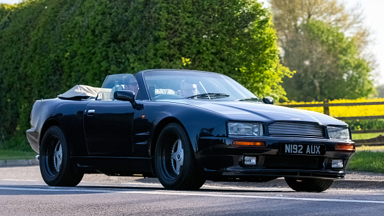 Bicester,UK- Apr 21st 2024: 1996 Aston Martin Virage Volante classic car driving on a British road