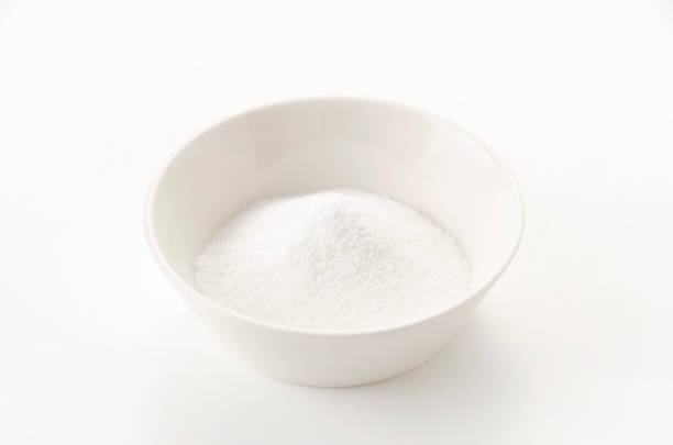 White bowl of baking soda on white background