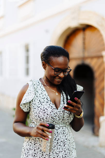 istock Smiling woman using phone on the street 2149613668