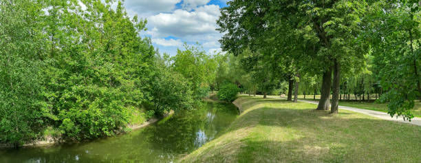 istock green park landscape with water canal and walking path on bank. panoramic image. 2149614478