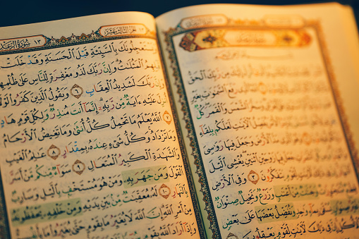 The Quran opens showing beautiful Arabic characters.