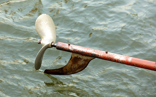 Metal propeller from a boat against the background of water.