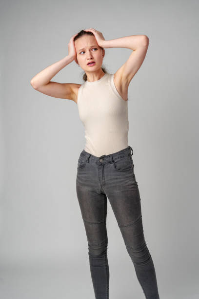 istock Young Woman Holding Head in Hands in studio 2149619917