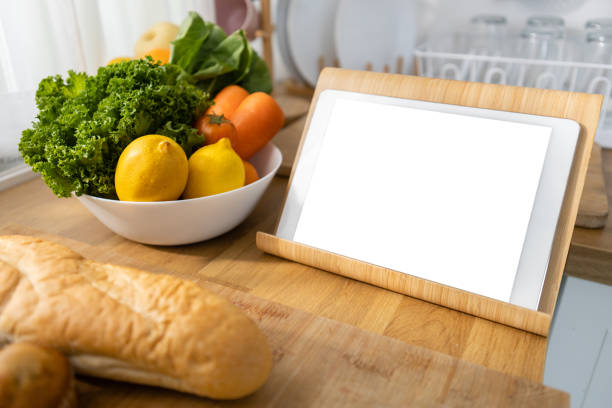 istock Tablet white screen on kitchen table with Vegetables, fruits and bread. Clipping path. Mockup display empty space use for graphic advertising text. Display live food online media. 2149620579