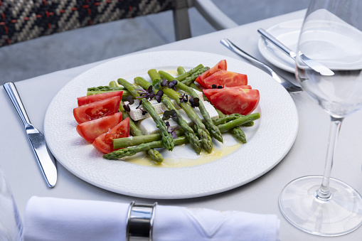 Caprese salad with asparagus served on a plate in the restaurant