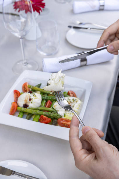 istock Hands eating caprese salad with asparagus 2149620927
