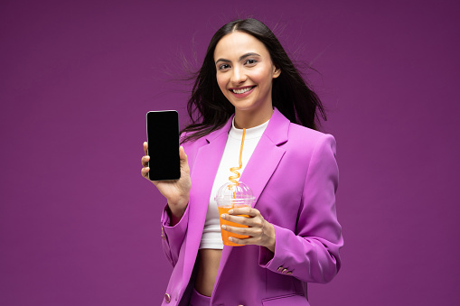 Portrait of her she nice well-dressed attractive lovely luxury pretty cheerful girl drinking juice isolated purple background