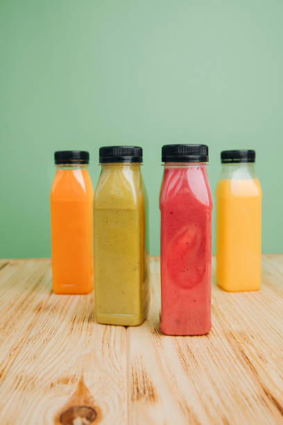istock Fruit and vegetable smoothies in transparent plastic bottles. Green, red, orange smoothies on a green and wooden background. The concept of healthy eating 2149621610
