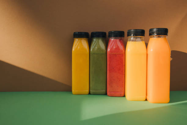 istock Fruit and vegetable smoothies in transparent plastic bottles. Red, green, orange smoothies on a brown-green background 2149621615