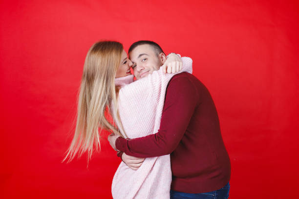 Young man and woman embracing each other, studio shot
