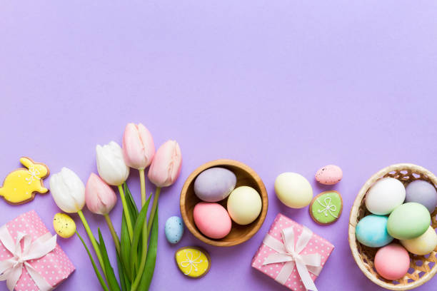 istock Easter frame with eggs, gift box and tulip on a colored background. The minimal concept. Top view Happy Easter composition. Card with a copy space of the place for the text 2149622454