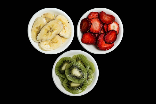 A photo of three bowls containing different varieties of fresh fruit, showcasing their vibrant colors and juicy textures.