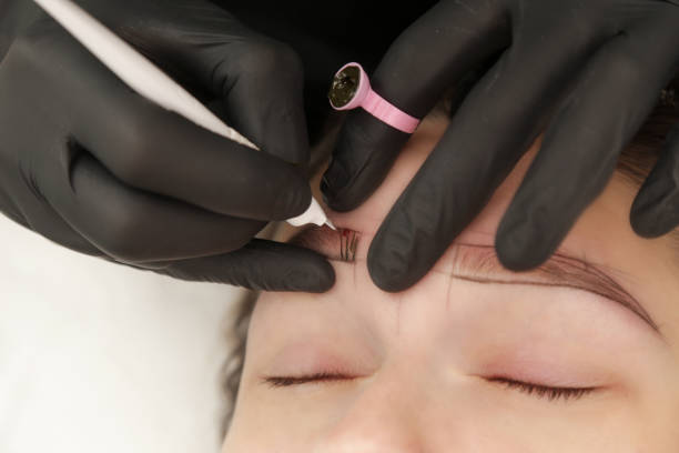 istock Microblading - semi-permanent tattooing technique used for the eyebrows by creating an illusion of a more defined and fuller brow. Artist makes tiny hair-like strokes to create a natural looking brows 2149622559