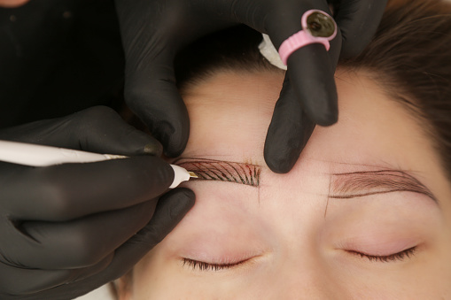 Microblading - semi-permanent tattooing technique used for the eyebrows by creating an illusion of a more defined and fuller brow. Artist makes tiny hair-like strokes to create a natural looking brows