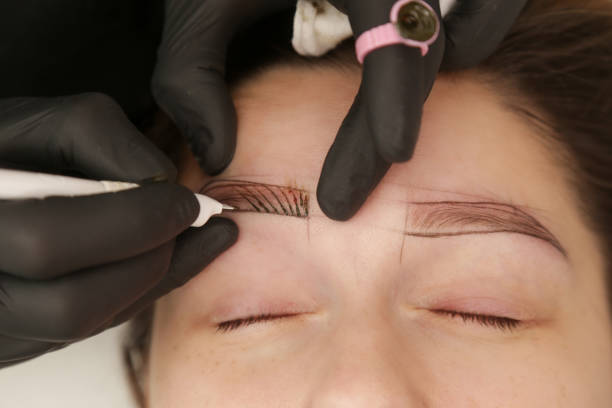 istock Microblading - semi-permanent tattooing technique used for the eyebrows by creating an illusion of a more defined and fuller brow. Artist makes tiny hair-like strokes to create a natural looking brows 2149622777