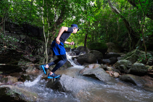 istock Runner, he's running a trail. In a natural path with a stream 2149623317