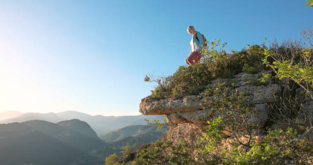 istock Mature hiker pauses on cliff edge 2149624371