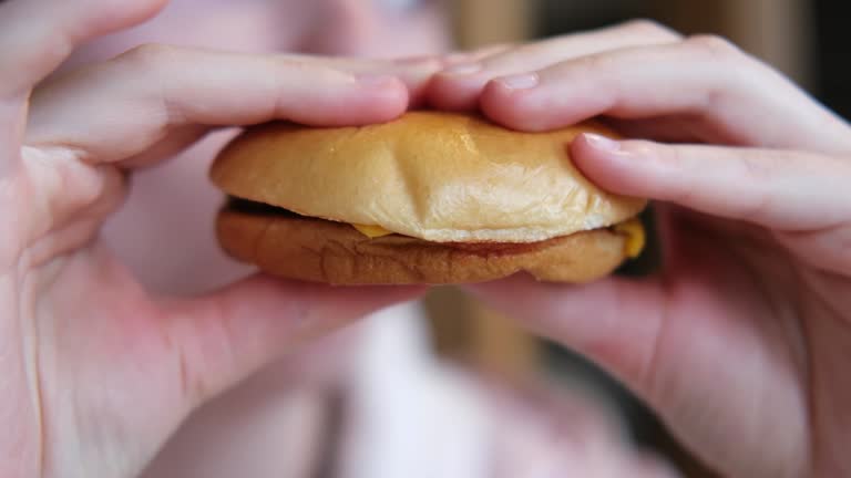 A close-up of a hamburger in his hands