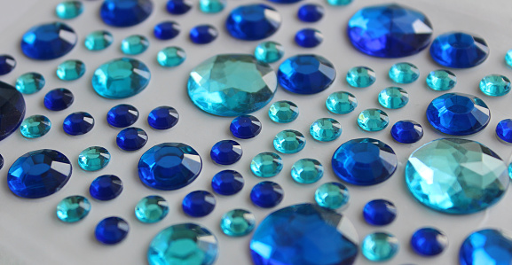 Variety Size And Blue Shades Faceted Crystals On White Surface Closeup Angle View