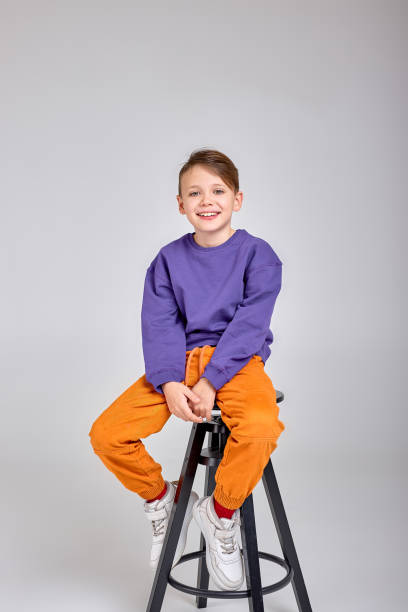 young happy boy sitting on chair isolated over white background, closeup portrait. free spare time, lifestyle. childhood. beauty, kid looks at camera