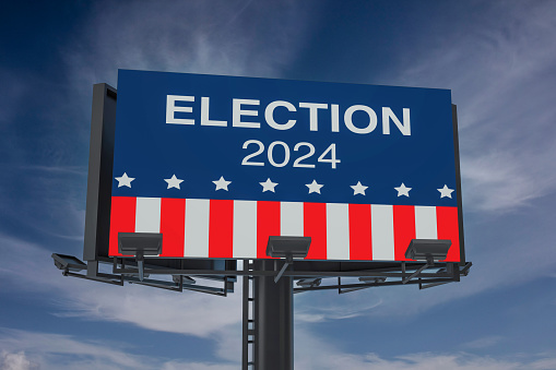 An imposing digital billboard displays 'ELECTION 2024' with an American flag motif, set against a dramatic cloudy sky