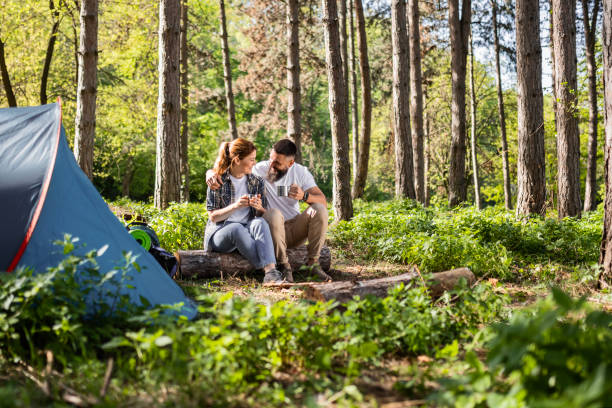 istock Happy Couple Relaxing with Coffee by Tent in Forest 2149627489