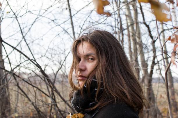 istock Young woman with long brown hair standing in a sparse forest. 2149628112