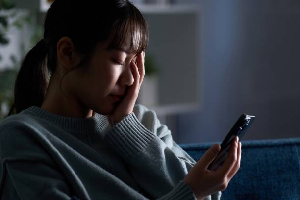 istock A depressed woman looking at her smartphone 2149628216