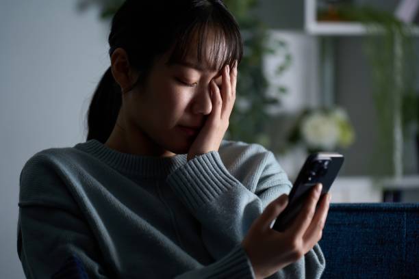 istock A depressed woman looking at her smartphone 2149628217