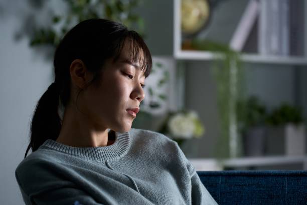 istock A woman thinking in a dark room 2149628224