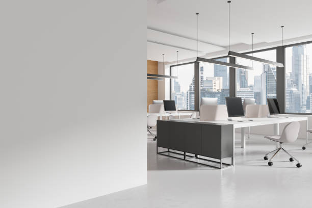 istock Stylish coworking interior with desk and pc desktop, window. Mockup wall 2149630062