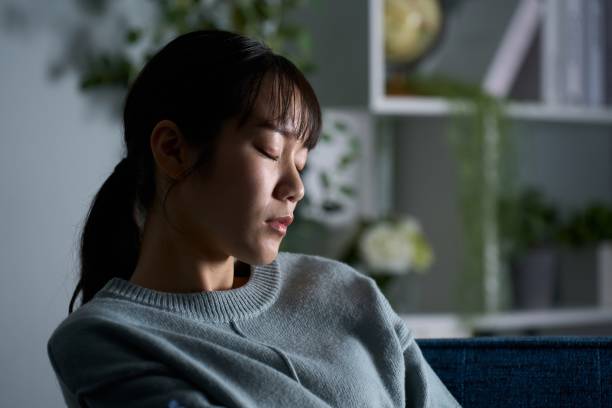 Woman closing her eyes in a dark room