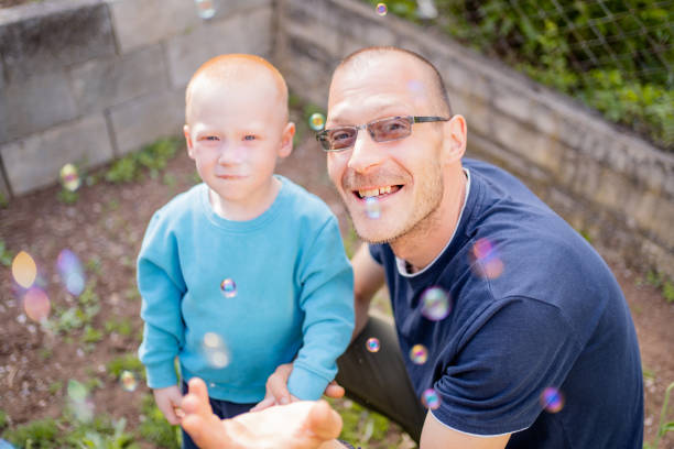 istock Happy dad and his little son playing with soap bubbles 2149631151