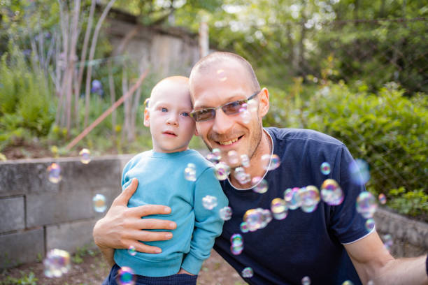 istock Happy dad and his little son playing with soap bubbles 2149631322