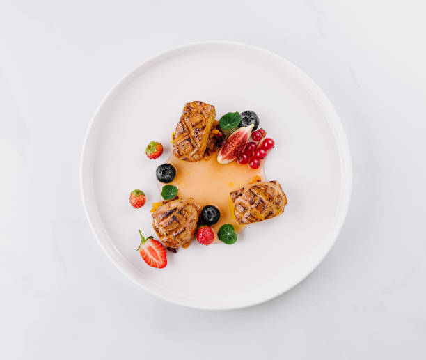 istock Elegant gourmet meat with berries on white plate 2149631477