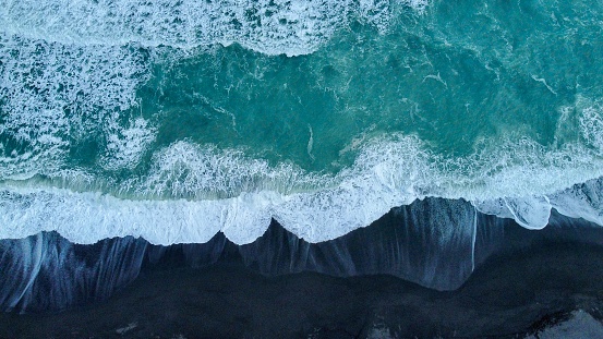aerial view of a pristine black sand beach