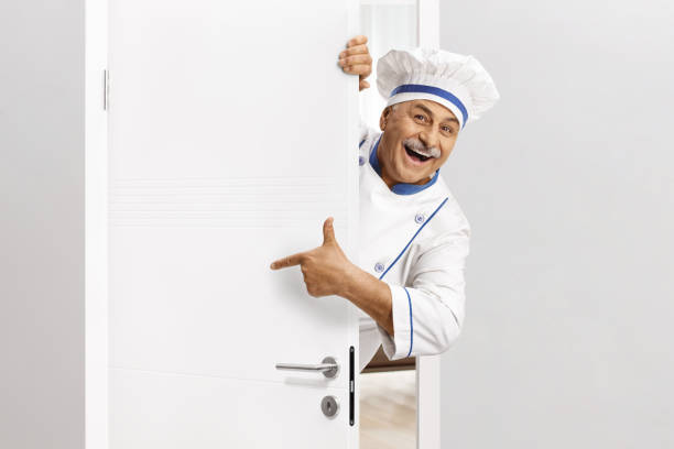 istock Chef in a uniform opening a door 2149631973