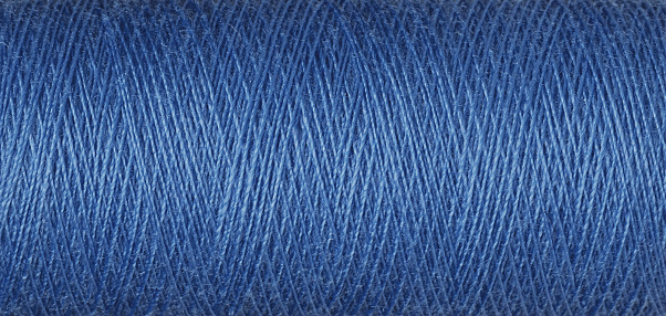 macro texture of a skein of blue sewing thread close-up