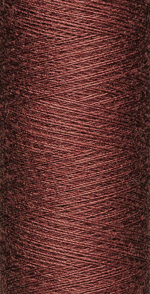 macro texture of a skein of brown sewing thread close-up