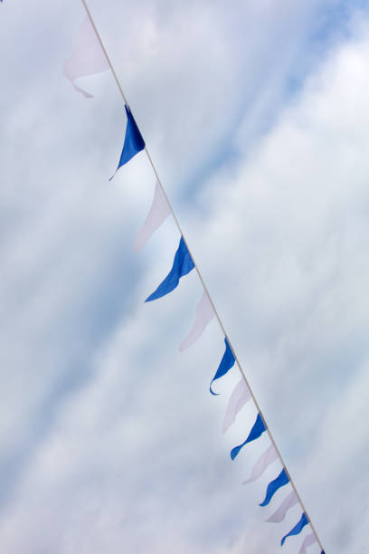 Festive blue white flags against the sky with clouds.