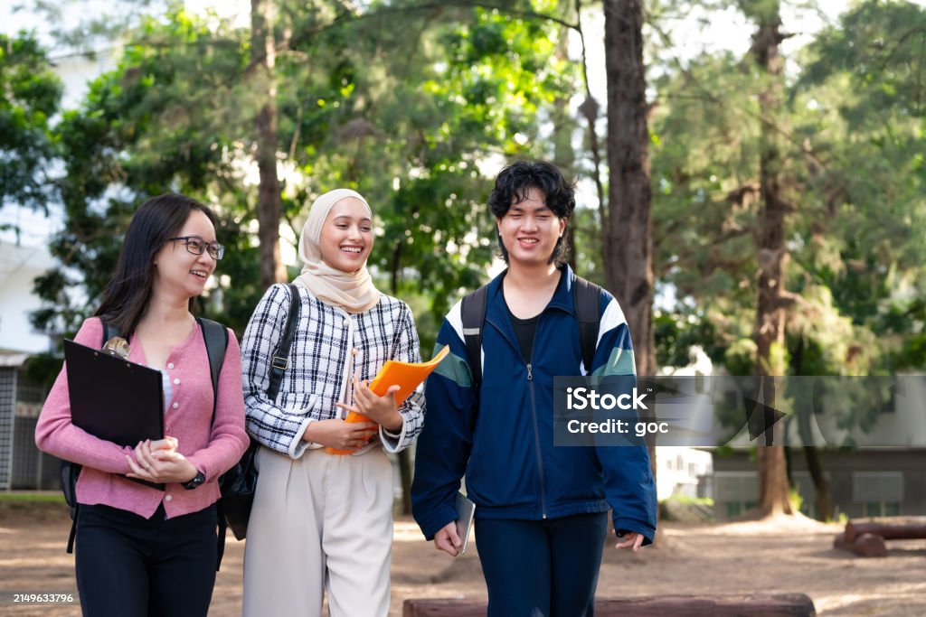 Three Young University Students Carrying School Bags And Document ...
